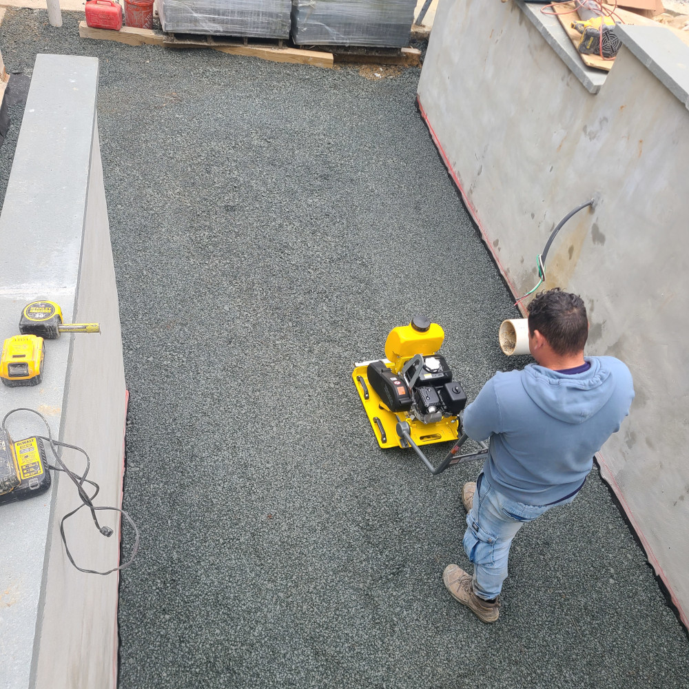 Construction worker using a plate compactor